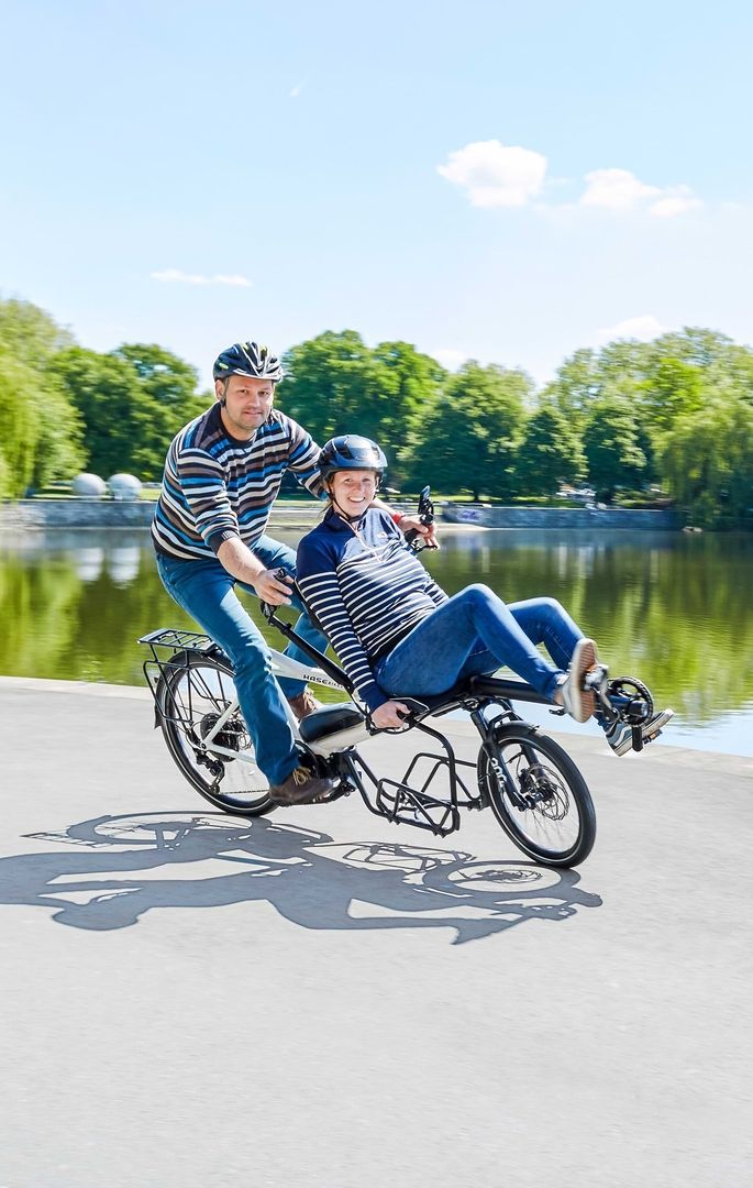 Ein Mann und eine Frau fahren gemeinsam auf einem Fahrrad durch eine malerische Landschaft.