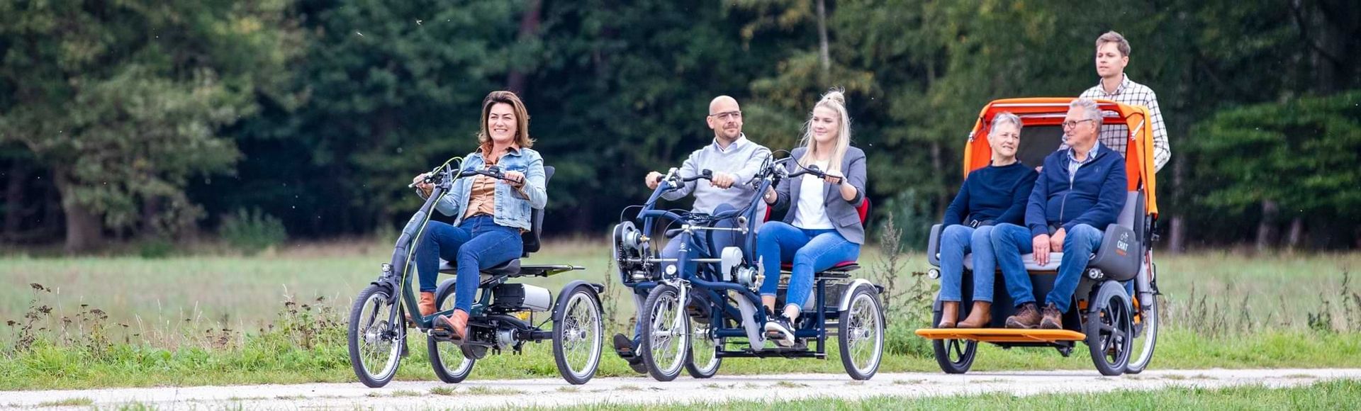 Eine Gruppe von Menschen fährt mit Fahrrädern auf einem Weg entlang.